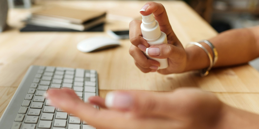 Employee sanitising at the desk